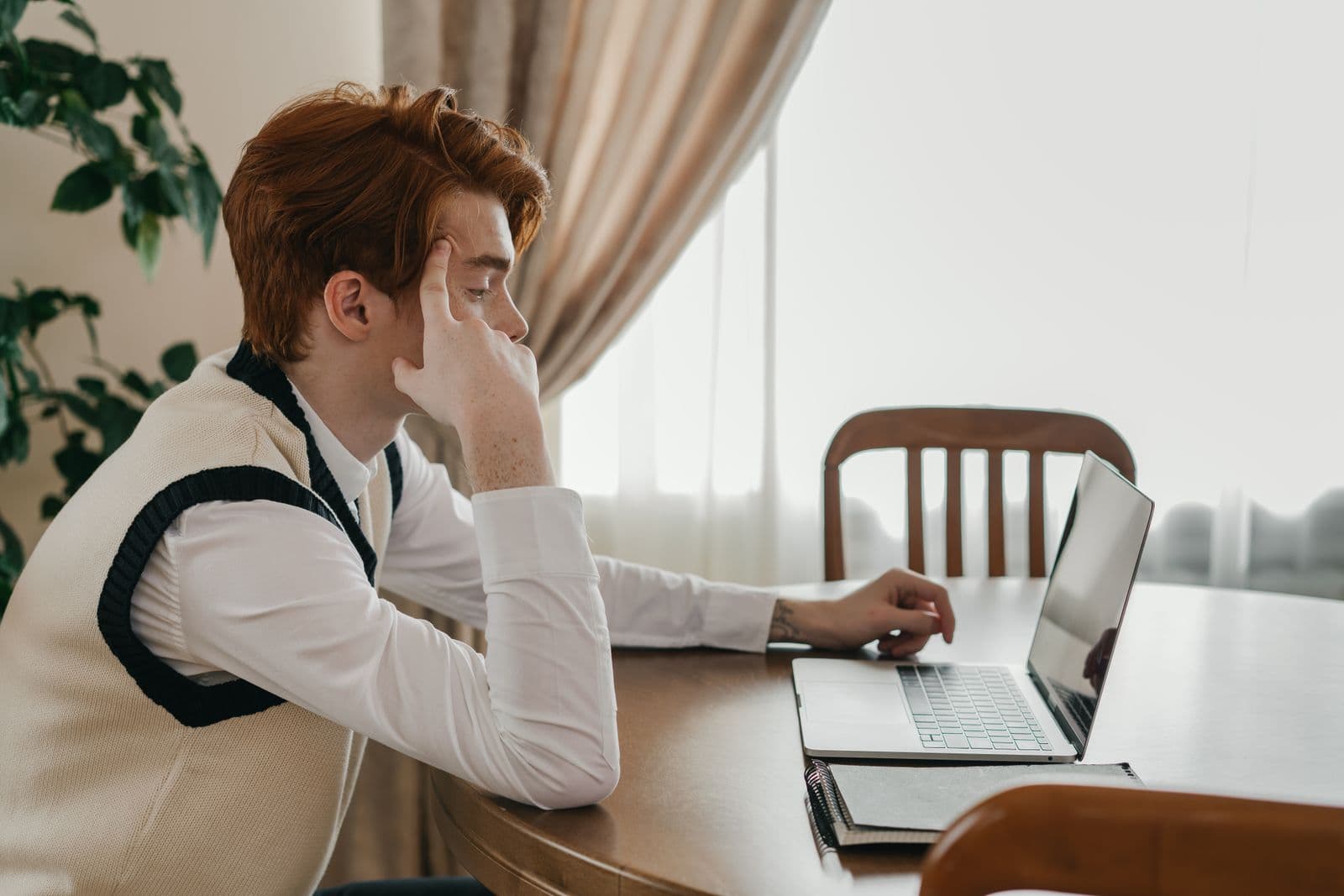 Een man werkt ontspannen op een laptop in een lichte woonomgeving